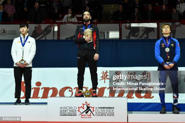 Hyo Jun Lim of Korea , Charles Hamelin of Canada and Semen Elistratov of Russia stand as the Canadian anthem is played during the World Short Track...