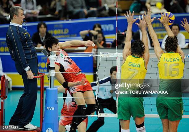 Kunihiro Shimizu of Japan attemps to spike the ball over Gilberto Godoy Filho and Lucas Saatkamp of Brazil during their match at the men's Grand...