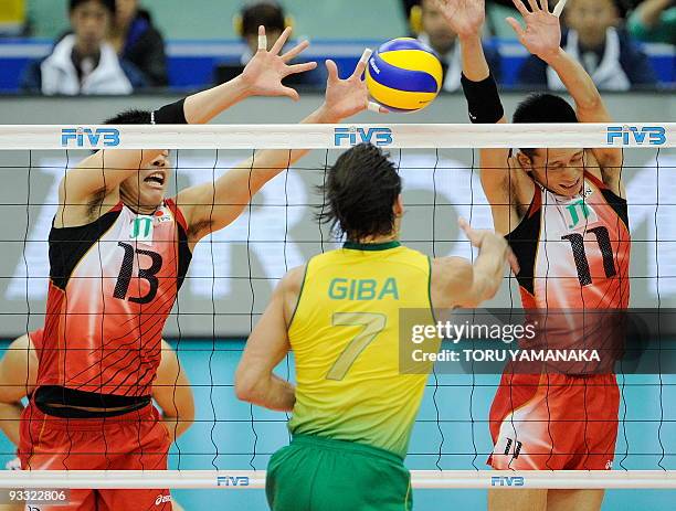 Kunihiro Shimizu and Yoshihiko Matsumoto of Japan try to block the ball from Gilberto Godoy Filho of Brazil during their match at the men's Grand...