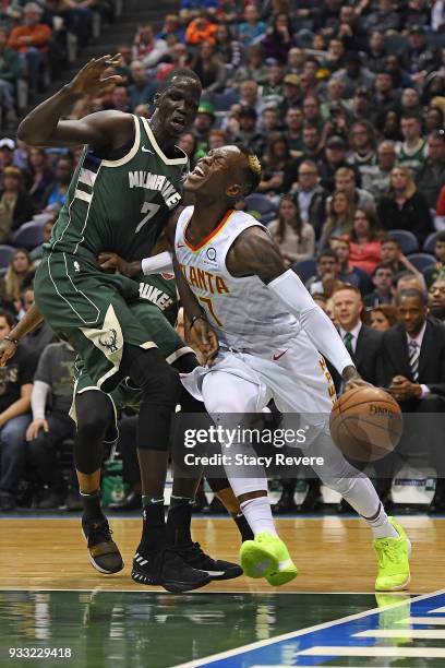 Dennis Schroder of the Atlanta Hawks is fouled by Thon Maker of the Milwaukee Bucks during the first half of a game at the Bradley Center on March...