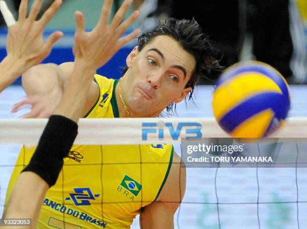 Gilberto Godoy Filho of Brazil spikes the ball past Yoshihiko Matsumoto of Japan during the men's Grand Championship Cup volleyball tournament in...
