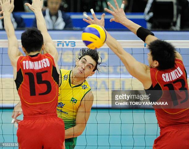Gilberto Godoy Filho of Brazil spikes the ball through Takaaki Tomimatsu and Kunihiro Shimizu of Japan during the men's Grand Championship Cup...