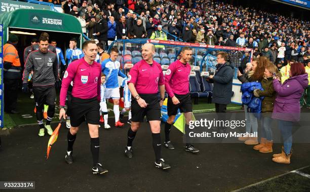 Referee Mike Dean with Assistant referees Eddie Smart and Mark Scholes lead out the teams for the Premier League match between Huddersfield Town and...