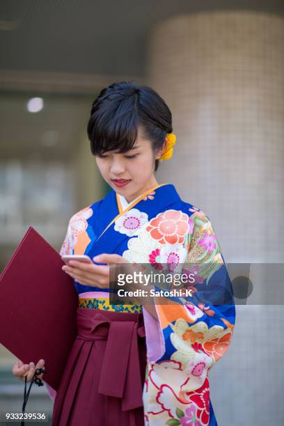 袴的年輕女子在智慧手機上閱讀資訊 - suginami 個照片及圖片檔