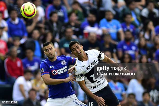 Cruz Azul's Spanish midfielder Edgar Mendez and Pumas' defender Luis Fuentes jump for the ball during their Mexican Clausura football tournament...