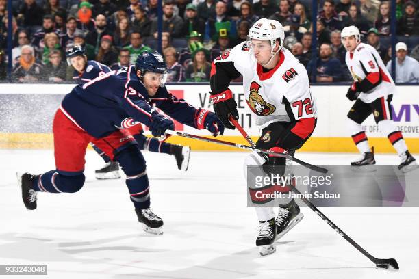Boone Jenner of the Columbus Blue Jackets sticks checks Thomas Chabot of the Ottawa Senators in the first period as Chabot starts a breakout on March...