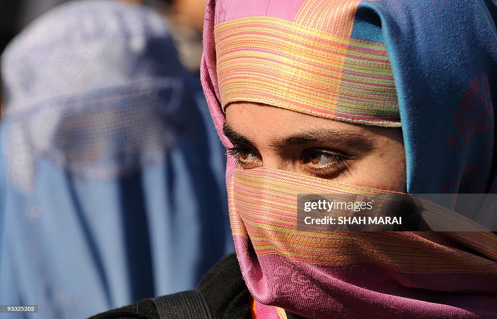 Burqa-clad Afghan women walk during a de
