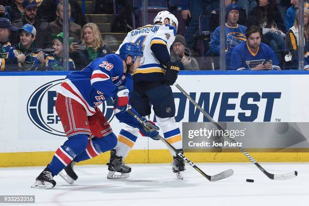 Paul Carey of the New York Rangers and Carl Gunnarsson of the St. Louis Blues look for control of the puck at Scottrade Center on March 17, 2018 in...