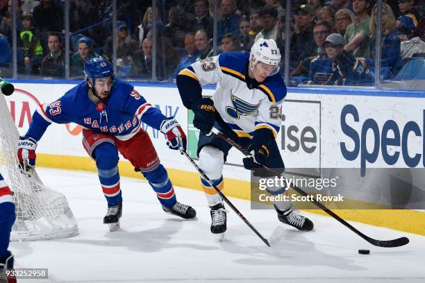 Mika Zibanejad of the New York Rangers defends against Dmitrij Jaskin of the St. Louis Blues at Scottrade Center on March 17, 2018 in St. Louis,...