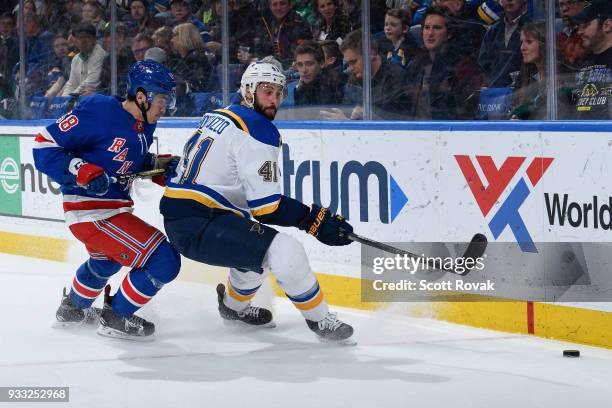 John Gilmour of the New York Rangers defends against Robert Bortuzzo of the St. Louis Blues at Scottrade Center on March 17, 2018 in St. Louis,...