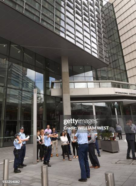 This photo taken on March 14, 2018 shows police speaking outside the International Convention Centre in Sydney which hosts a special summit with...