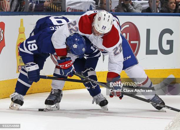 Karl Alzner of the Montreal Canadiens battles against Tomas Plekanec of the Toronto Maple Leafs during an NHL game at the Air Canada Centre on March...