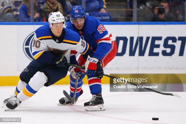 John Gilmour of the New York Rangers defends against Nikita Soshnikov of the St. Louis Blues at the Scottrade Center on March 17, 2018 in St. Louis,...