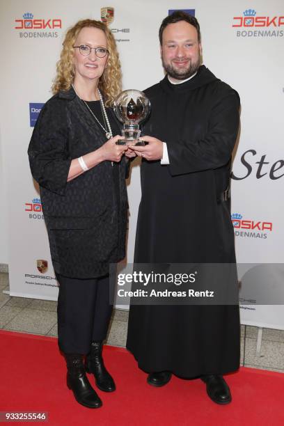 Anne Geddes poses with her award as Father Nikodemus Schnabel smiles during the Steiger Award at Zeche Hansemann on March 17, 2018 in Dortmund,...