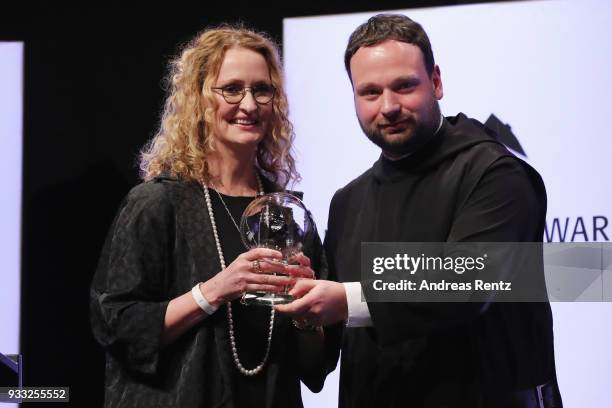 Anne Geddes poses with her award as Father Nikodemus Schnabel smiles during the Steiger Award at Zeche Hansemann on March 17, 2018 in Dortmund,...