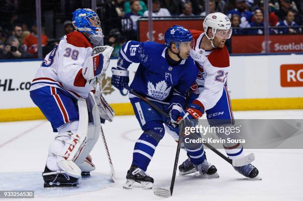 Tomas Plekanec of the Toronto Maple Leafs battles with Karl Alzner of the Montreal Canadiens in front of Charlie Lindgren of the Montreal Canadiens...