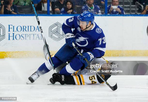 Adam Erne of the Tampa Bay Lightning slides against Adam McQuaid of the Boston Bruins during the third period at Amalie Arena on March 17, 2018 in...