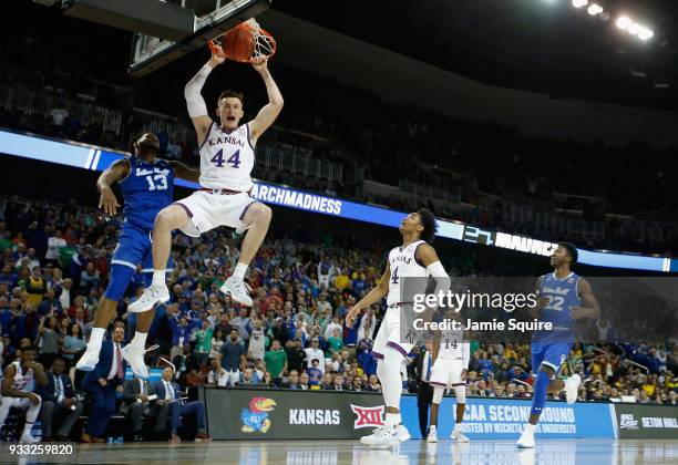 Mitch Lightfoot of the Kansas Jayhawks dunks against Myles Powell of the Seton Hall Pirates in the second half during the second round of the 2018...