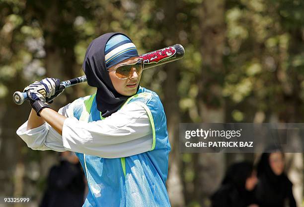 An Iranian woman meeting the Islamic dress code plays softball at Tehran's Azadi stadium 15 June 2006. Under the Islamic republic's strict rules,...