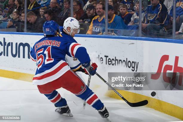 David Desharnais of the New York Rangers and Colton Parayko of the St. Louis Blues battle for the puck at Scottrade Center on March 17, 2018 in St....