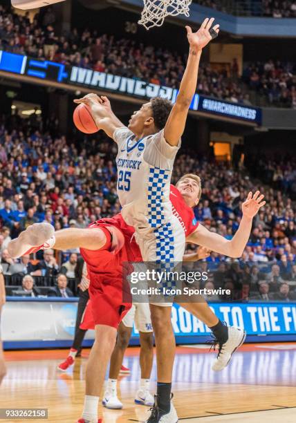 Peyton Aldridge of the Davidson Wildcats takes a fall under the basket after a block by F PJ Washington of the Kentucky Wildcats during the NCAA...