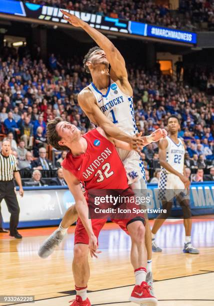 Sacha Killeya-Jones of the Kentucky Wildcats and G Rusty Reigel of the Davidson Wildcats get tangled up under the basket during the NCAA Division I...