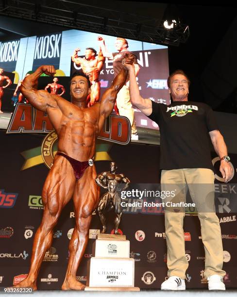 Arnold Schwarzenegger presents Byoung Chan of Korea with the winners trophy for the Arnold Amateur Bodybuilding event, during the Arnold Sports...