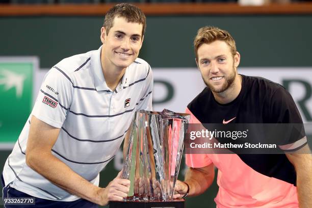 John Isner and Jack Sock pose with the winner's trophy after defeating Mike Bryan and Bob Bryan during the men's doubles final on Day 13 of the BNP...