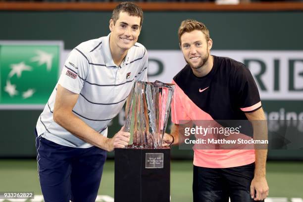 John Isner and Jack Sock pose with the winner's trophy after defeating Mike Bryan and Bob Bryan during the men's doubles final on Day 13 of the BNP...