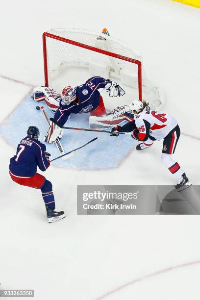 Sergei Bobrovsky of the Columbus Blue Jackets stops a shot from Erik Karlsson of the Ottawa Senators as Jack Johnson of the Columbus Blue Jackets...