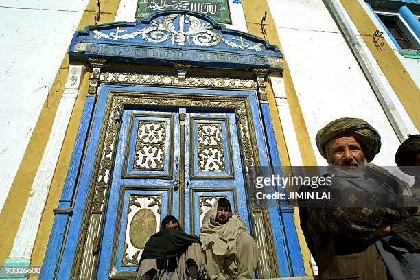 Afghan men sit outside the shrine of Hazrat Alli, a Muslim prophet and the son-in-law of the prophet Mohammad, in North Kabul, 07 December 2001....
