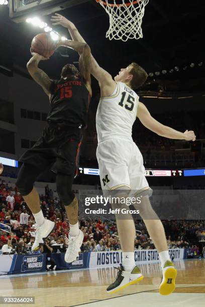 Devin Davis of the Houston Cougars shoots against Jon Teske of the Michigan Wolverines in the first half during the second round of the 2018 NCAA...