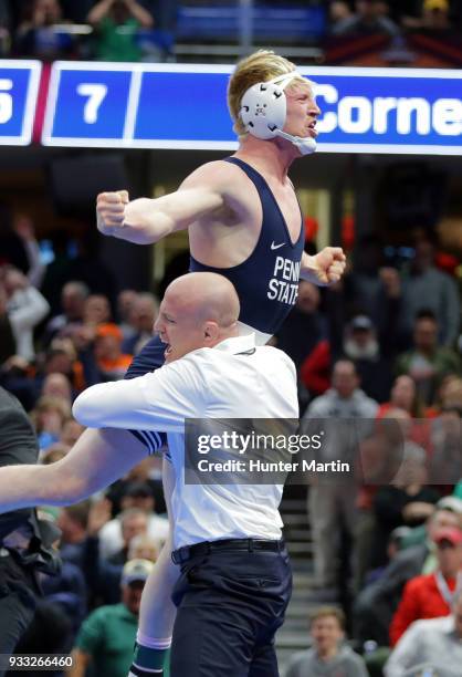 Bo Nickal of the Penn State Nittany Lions celebrates with head coach Cael Sanderson after winning the 184 pound championship match and clinching the...