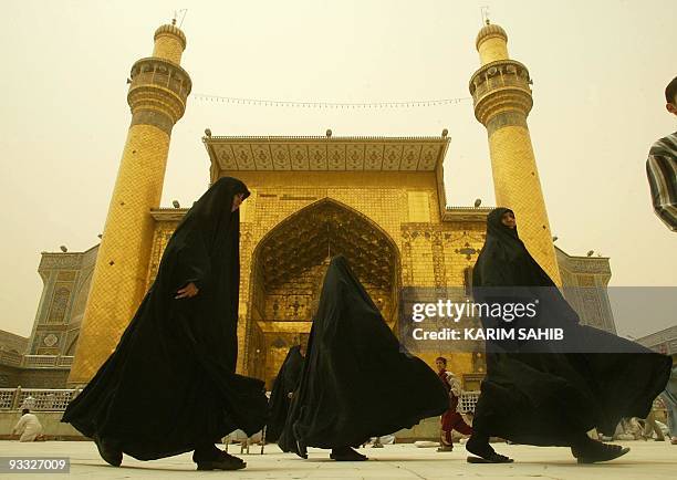 Muslim Shiite Iraqi women walk in the shrine of Imam Ali in Najaf 15 April 2003. Iraq has already witnessed a surge in religious violence since...