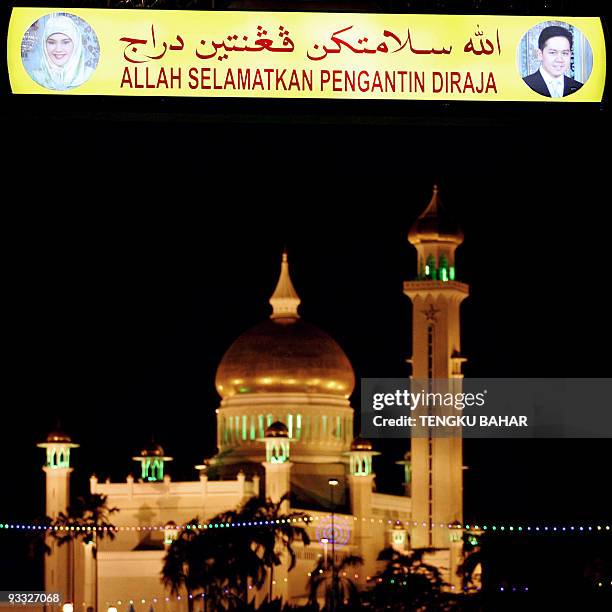 Backlit archway sign that reads "God save the Royal Couple", flanked with portraits of Princess Majeedah Nuurul Bulqiah and Pengiran Khairul Khalil,...