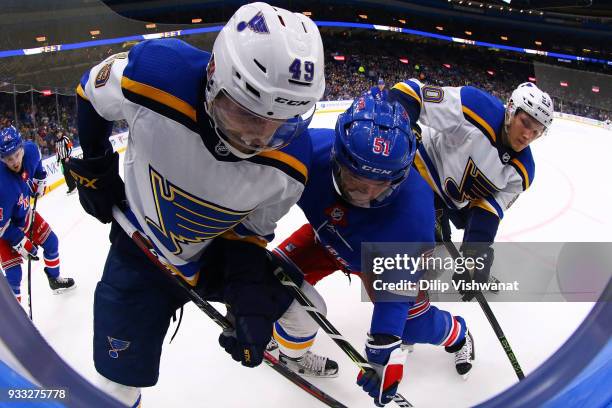 Ivan Barbashev nd Nikita Soshnikov of the St. Louis Blues fight David Desharnais of the New York Rangers for the puck at the Scottrade Center on...