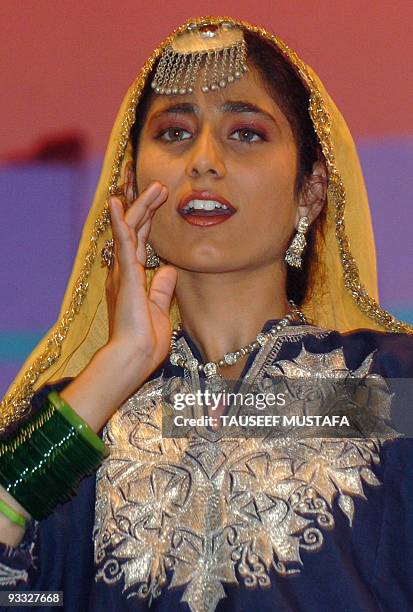 Kashmiri Muslim woman wears traditional dress as she sings during a ceremony in Srinagar, 15 September 2006, held to mark the 47th Doordarshan...