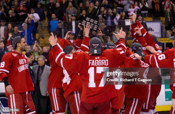 Dante Fabbro of the Boston University Terriers and his teammates celebrate after the Terriers won the Hockey East Championship 2-0 against the...