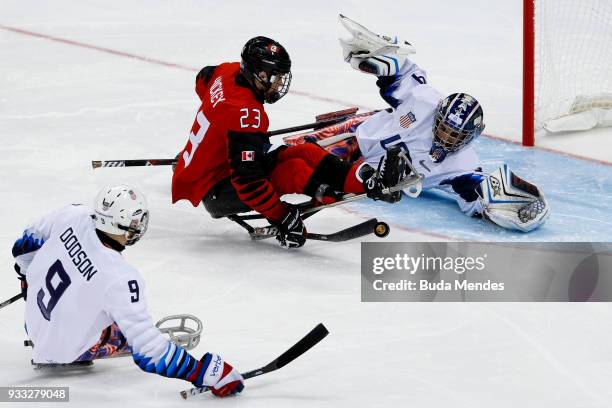 Liam Hickey of Canada battles for the puck with goalkeeper Steve Cash of the United States in the Ice Hockey gold medal game between United States...