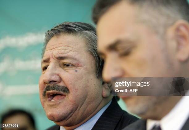 Kurdish MP Mohsin Saadun speaks to the press as Bahaa al-Araji, chairman of the Iraqi Parliamentary Law Committee, listens on at a press conference...