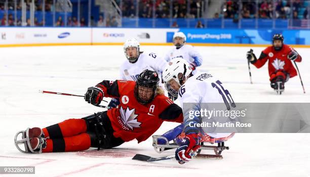 Adam Dixon of Canada battles for the puck with Declan Farmer of United States in the Ice Hockey gold medal game between Canada and United States...