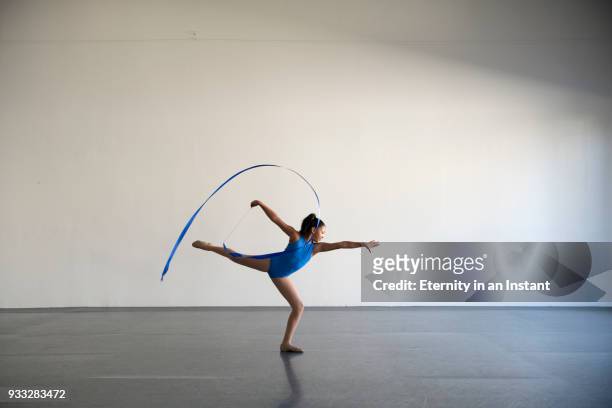 mixed race girl dancing in a gymnasium with a ribbon - ribbon dance stock-fotos und bilder