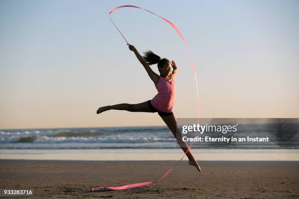 young mixed race girl dancing on the beach at sunset - ribbon dance stock pictures, royalty-free photos & images