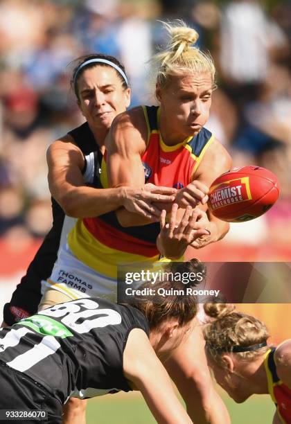 Erin Phillips of the Crows handballs whilst being tackled during the round seven AFLW match between the Collingwood Magpies and the Adelaide Crows at...