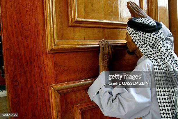 Shiite Iraqi kisses the door of Imam Ali's Shrine in the holy city of Najaf south of Baghdad late 13 October 2006 as Shiites headed from all over the...