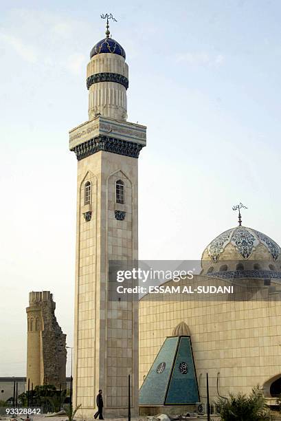 An Iraqi walks past the new minaret of Shiite Imam Ali's historical mosque in the southern Iraqi city of Basra at sunset, late 20 February 2007. The...