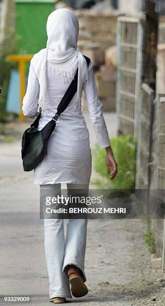 An Iranian woman walks at a street in Tehran, 13 July 2004. A fresh crackdown by Iranian police targeting insufficiently veiled women has prompted a...