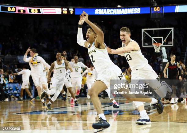 Jordan Poole and Moritz Wagner of the Michigan Wolverines celebrate Poole's 3-point buzzer beater for a 64-63 win over the Houston Cougars during the...