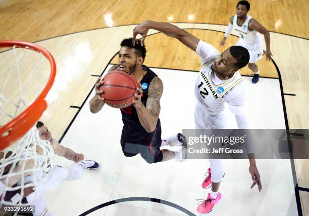 Devin Davis of the Houston Cougars drives past Muhammad-Ali Abdur-Rahkman of the Michigan Wolverines during the second round of the 2018 NCAA Men's...