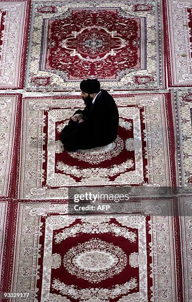 An Iraqi Shiite cleric prays at Imam Ali shrine in the holy city of Najaf, central Iraq, 17 January 2008. Tens of thousands of pilgrims from across...